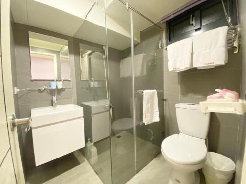 a bathroom with a toilet and a glass shower at Day Day Fengjia in Taichung
