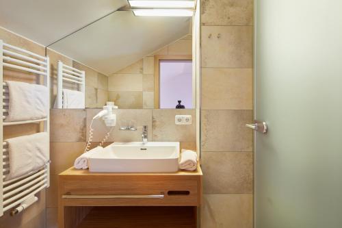 a bathroom with a sink and a mirror at Appartements am Stadtpark Zell am See in Zell am See