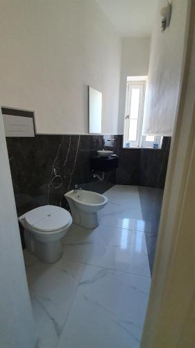 a bathroom with two toilets and a sink at Cannatella's Mansion in Palermo