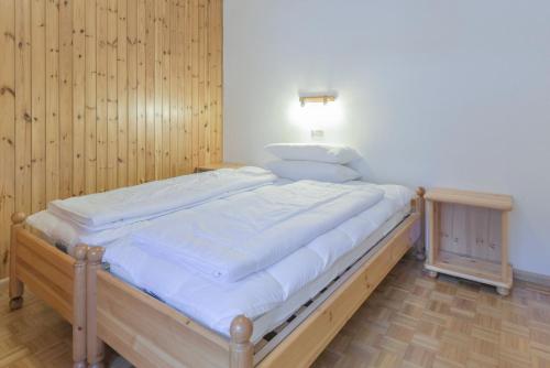 a large bed in a room with wooden walls at Cesa Ciampac 5 in Alba di Canazei