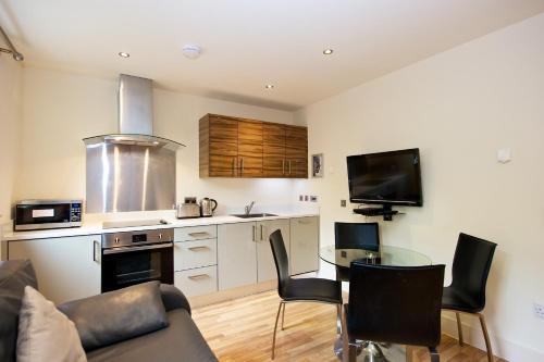 a kitchen with a stove a refrigerator and a microwave at Staycity Aparthotels West End in Edinburgh