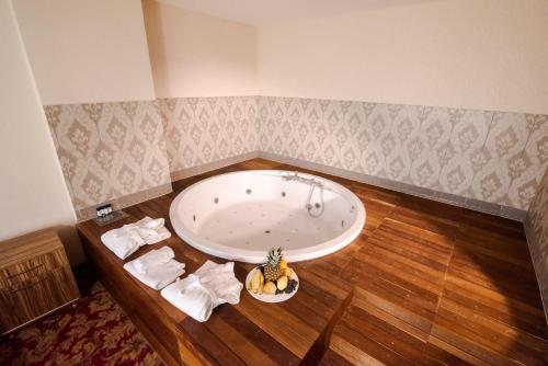bañera con plato de plátanos en el suelo de madera en Grand Hotel & Convention Center Karaman, en Karaman