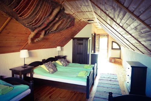 a bedroom with a bed in a room with an attic at Mazurska Zagroda in Rydzewo