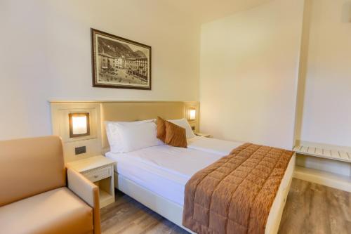 a hotel room with a bed and a chair at Hotel Sole Relax & Panorama in Riva del Garda