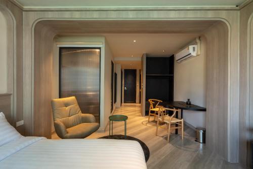 um quarto de hotel com uma cama, uma cadeira e uma mesa em The Spades Private Residence em Bangkok
