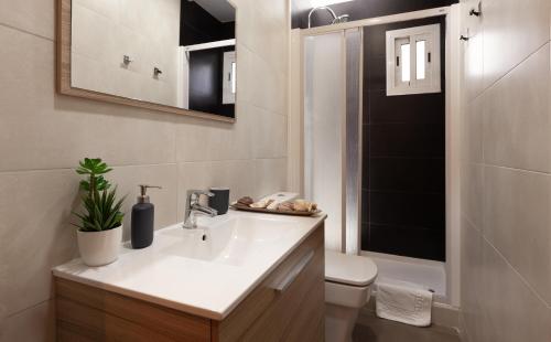 バルセロナにあるSunny Penthouse in Sagrada Familiaのバスルーム(洗面台、トイレ、鏡付)