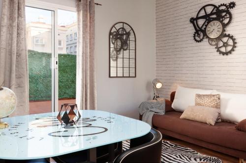 sala de estar con mesa de cristal y sofá en Sunny Penthouse in Sagrada Familia, en Barcelona