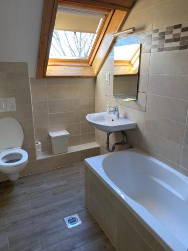 a bathroom with a tub and a sink and a toilet at Rómahegy Rendezvényház in Kaposvár