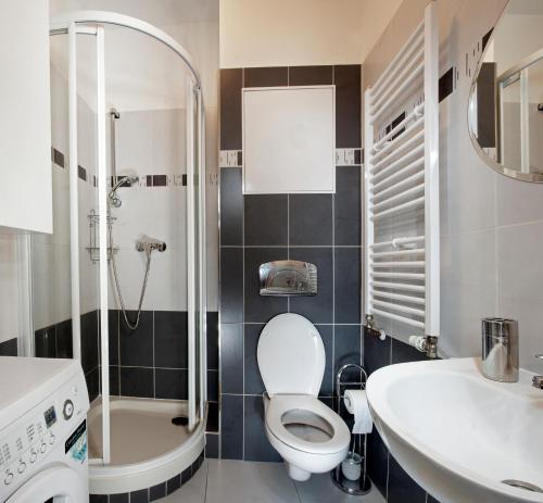 a bathroom with a toilet and a sink and a shower at Yellow apartment Deluxe in Brno