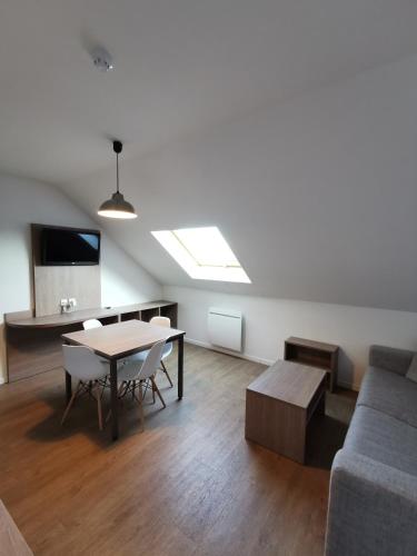 a living room with a table and a couch at Résidence Océane in Avrainville