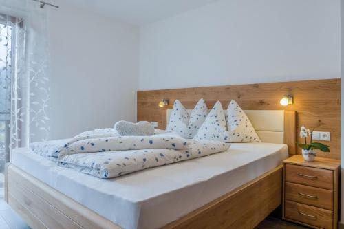 een slaapkamer met een groot wit bed met blauwe kussens bij Hofschenke Pfeiftal - Bergblick in San Martino