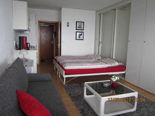 ティメンドルファー・シュトラントにあるSeeblick Apartment in Plaza Maritim Residenzのベッド1台とソファが備わる小さな客室です。