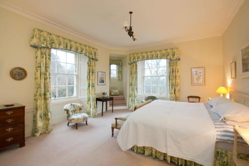 a bedroom with a large bed and two windows at Crookston House B&B 