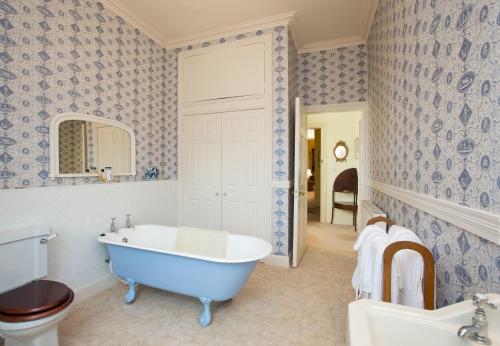 a bathroom with a tub and a toilet and a sink at Crookston House B&B 