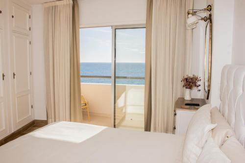 フエンヒロラにあるBeachfront apartment in Fuengirola with sea viewsの白いベッドルーム1室(海の景色を望む)