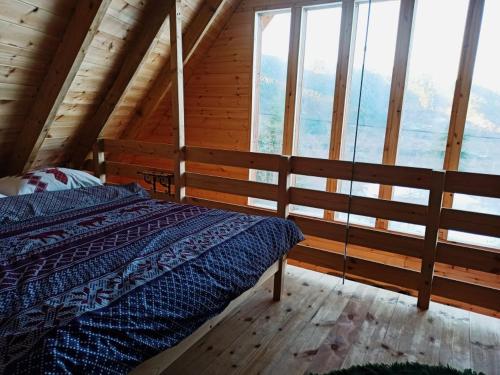 a bedroom with a bed in a cabin with windows at Kedra Village in Kédra