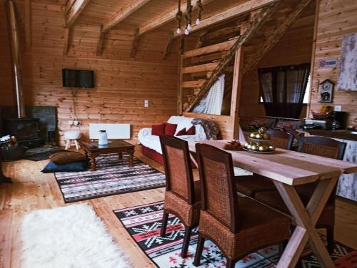 a living room with a table in a log cabin at Kedra Village in Kédra