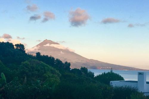 a mountain in the distance with a body of water at Summer house with BBQ and Garden in Horta