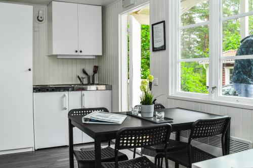 a kitchen with a table and chairs and a kitchen with white appliances at Ursand Resort & Camping in Vänersborg