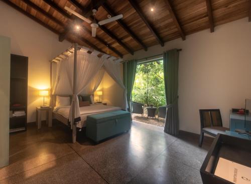 a bedroom with a canopy bed and a window at Wallawwa in Katunayake