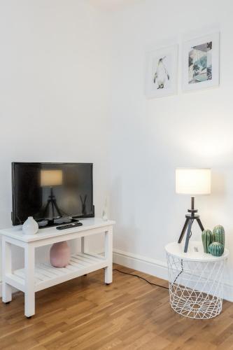 a living room with a tv on a white table at WelcomeStay Clapham Junction 2 Bedroom Apartment in London