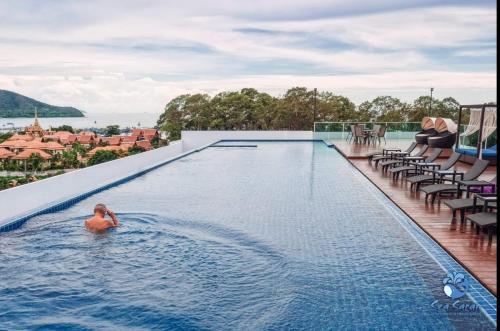 a woman in the infinity pool at a resort at Sea Saran Condominium for Short-Term Stay in Bang Sare