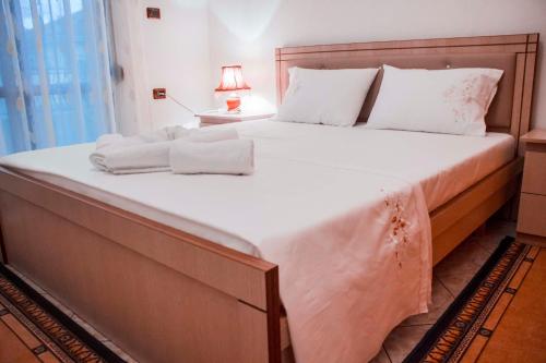 a large bed with white sheets and pillows on it at Artur's Apartment in Gjirokastër