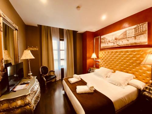 sypialnia z łóżkiem i biurkiem z komputerem w obiekcie Hotel Palace Sevilla w Sewilli