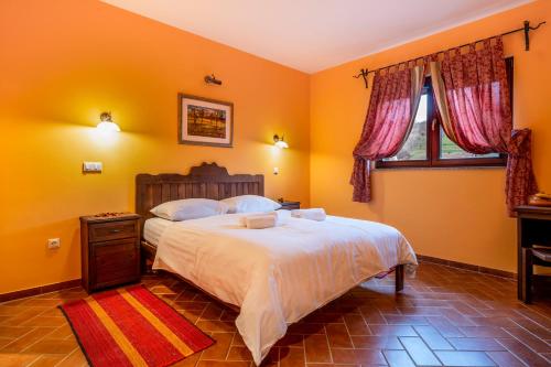 a bedroom with a large bed with yellow walls at Stupnički Dvori Winery Hotel in Brodski Stupnik