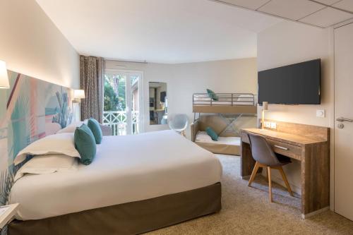 a hotel room with a large bed and a desk at Best Western Plus Hyères Côte D'Azur in Hyères