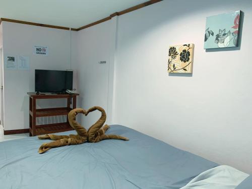 a room with a bed with a sculpture of a snake at Smile Resort in Ban Phai Cham Sin