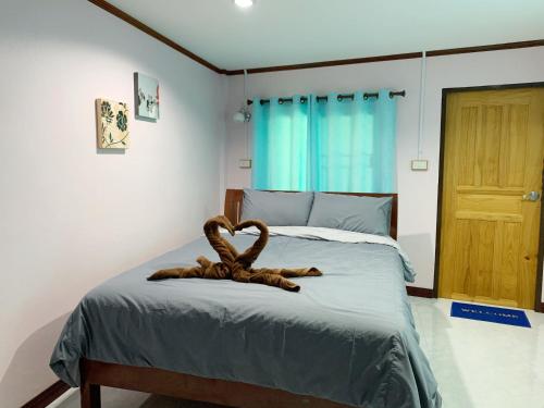a bedroom with a bed with a wooden head board at Smile Resort in Ban Phai Cham Sin