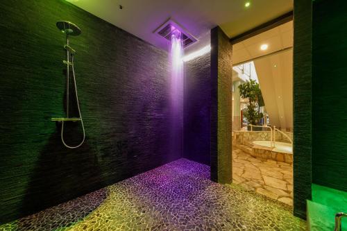baño con ducha con iluminación púrpura en Hotel Hochsauerland by Center Parcs en Medebach
