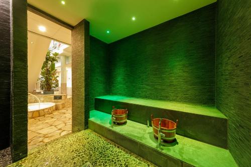 a green bathroom with a tub and a sink at Hotel Hochsauerland by Center Parcs in Medebach