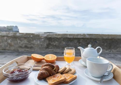 ein Tablett mit einem Frühstück mit Kaffee, Croissants und Orangen in der Unterkunft B&B La Riviera in Gallipoli