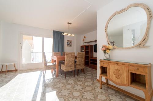 a dining room with a table and a mirror at HomeHolidaysRentals Bonte in Malgrat de Mar