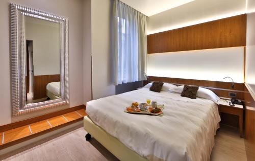 Habitación de hotel con cama y espejo en Best Western Madison Hotel, en Milán