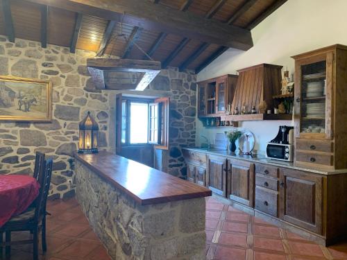 a kitchen with a stone wall and a counter top at Casa D'Campo Ferreira in Pitões das Júnias