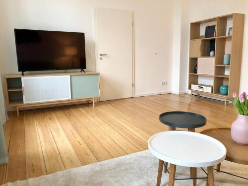 uma sala de estar com uma televisão de ecrã plano e uma mesa em Ferienapartment Warnemünde 2 em Warnemünde