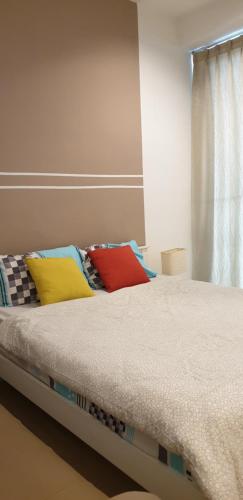 a bed with colorful pillows on it in a room at Capri Room in Kuala Lumpur
