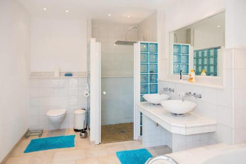 a white bathroom with two sinks and a shower at Schönste Lage am Rhein in unmittelbarer Stadtnähe, B & B in Cologne