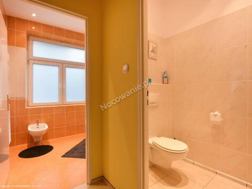 a bathroom with a toilet and a window at Apartament W sercu Krynicy in Krynica Zdrój