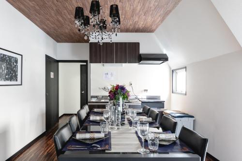 a dining room with a long table and chairs at Fuji Heights in Osaka