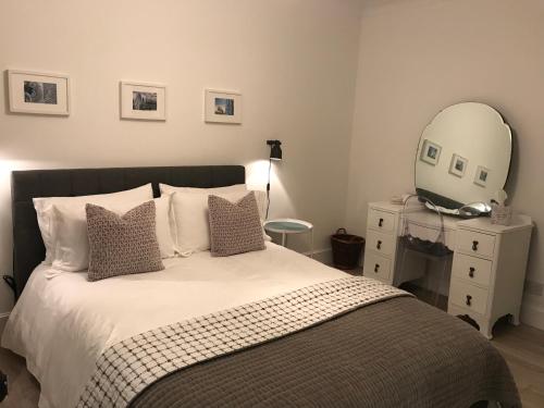 um quarto com uma cama com um espelho e uma cómoda em CROFT 14 SWORDALE em Swordale