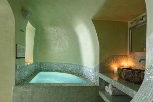 a bathroom with a large tub and a sink at Above Blue Suites in Imerovigli