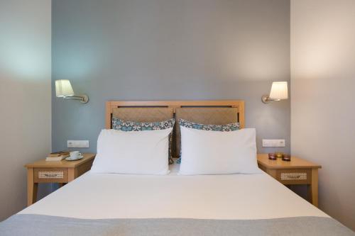 a bedroom with a large bed with white sheets and pillows at Anna Plakias Apartments in Plakias