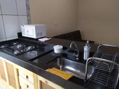 a kitchen counter with a sink and a stove at casa temporada capitólio in Capitólio
