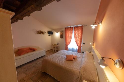 a bedroom with two beds and a window at Agriturismo La Dimora Del Contadino in Mondovì