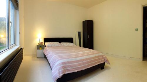 a bedroom with a bed and a large window at Spacious double bedrooms sharing new bathroom, en-suite option available, Kings Lynn in Kings Lynn