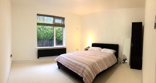 een witte slaapkamer met een bed en een raam bij Spacious double bedrooms sharing new bathroom, en-suite option available, Kings Lynn in Kings Lynn